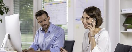 Male and female project manager collaborating in front of computer screen at office