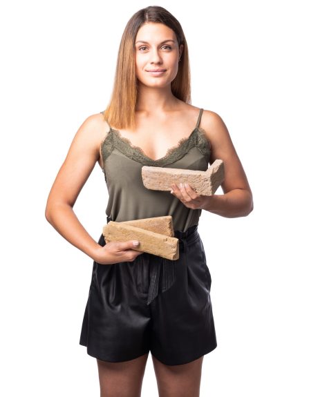 Mladá žena držící v rukou ražené lícové cihly a obkladové pásky ražené Terca na bílém pozadí