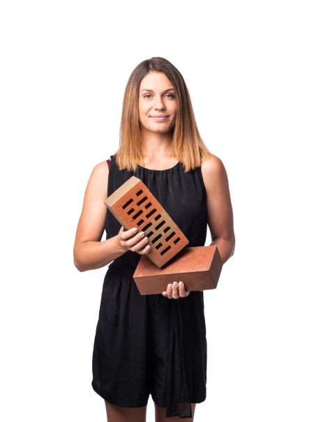 Mladá žena držící v rukou tažené lícové fasádní cihly Terca Klinker