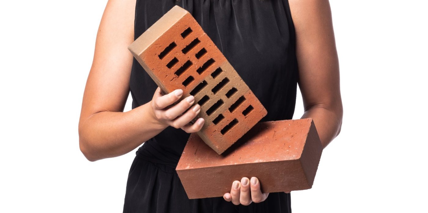 Mladá žena držící v rukou tažené lícové fasádní cihly Terca Klinker