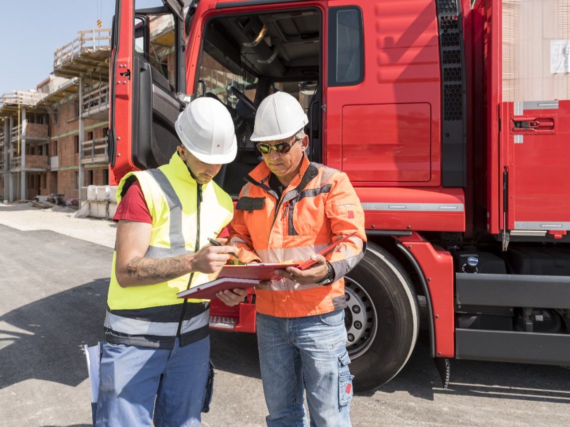 Construction worker signs delivery slip