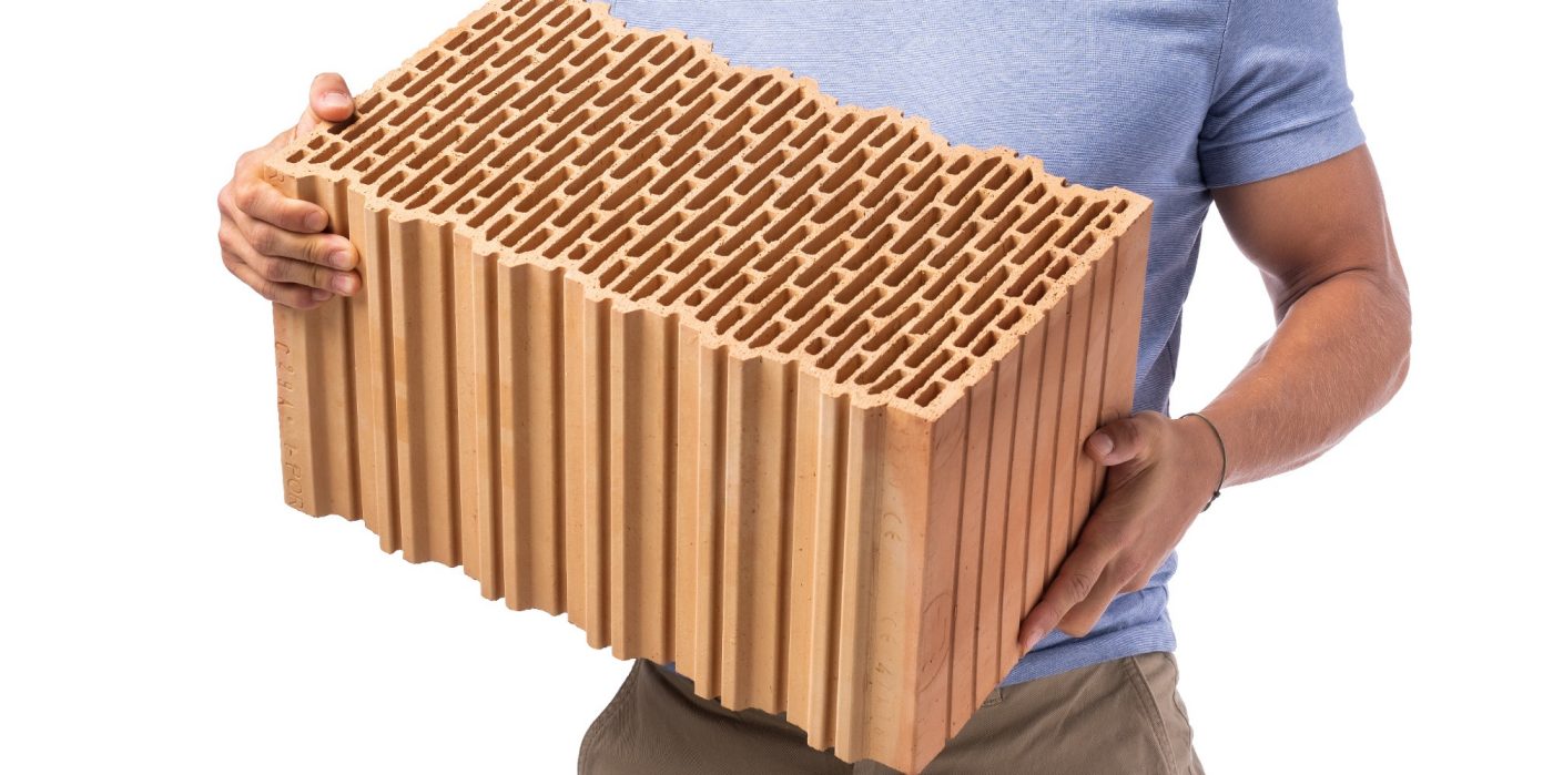 Mladý muž s cihlou Porotherm EKO+ Profi | Lifestyle