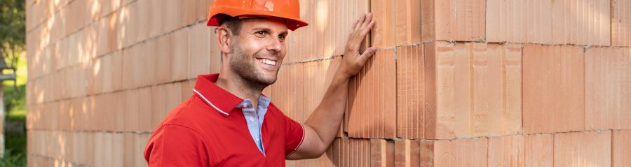 Muž sahající na zeď z jednovrstvého zdiva